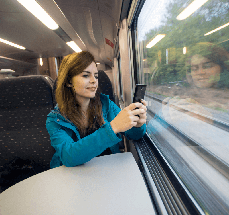 Tren Mini Ruta de Italia Mujer tomando una foto por una ventana de tren con su celular