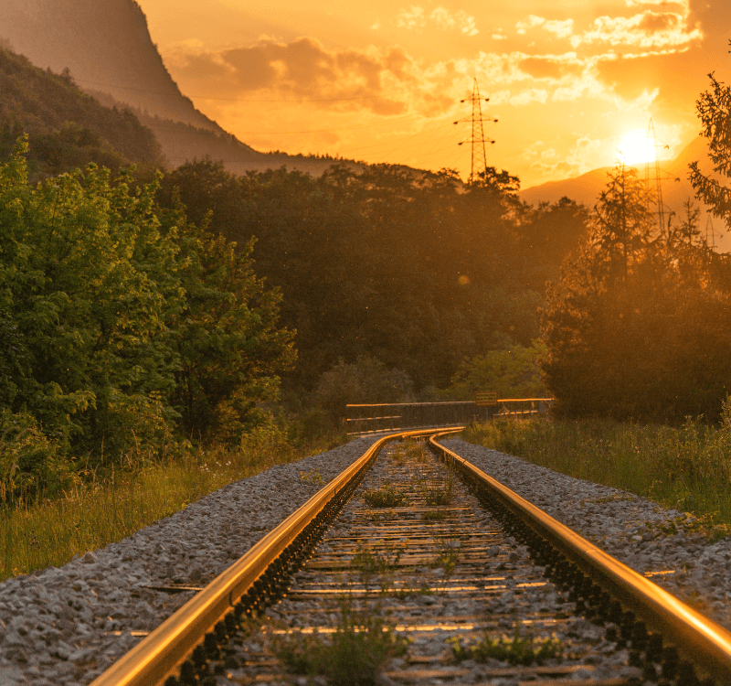 Pince Med Línea de tren con un atardecer al fondo